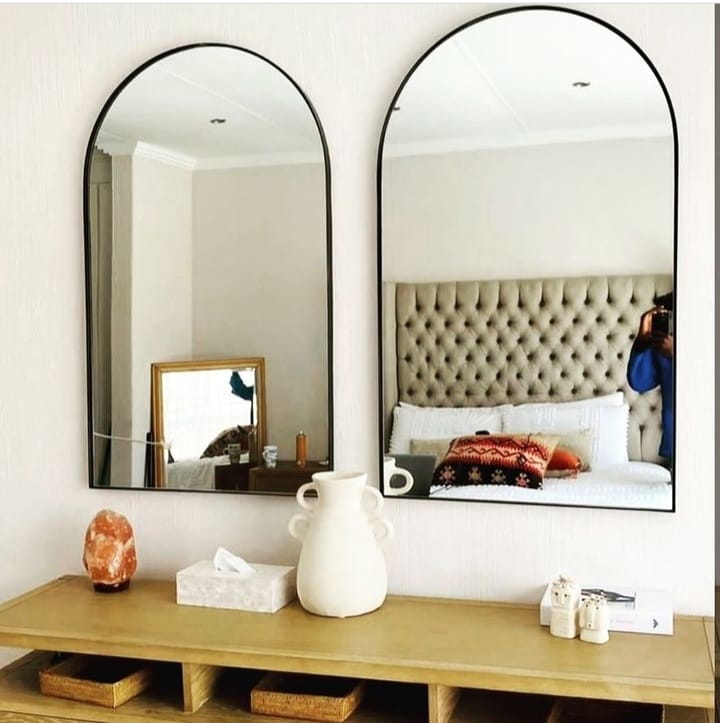 Pair of slim black arch framed mirrors above bedroom console — Mirror Art Gallery