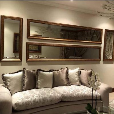 Bronze gold framed mirror cluster arrangement above lounge sofa — Mirror Art Gallery
